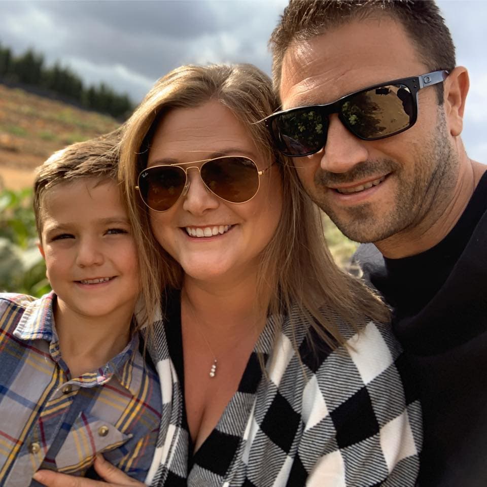 A child posing with a mom and dad